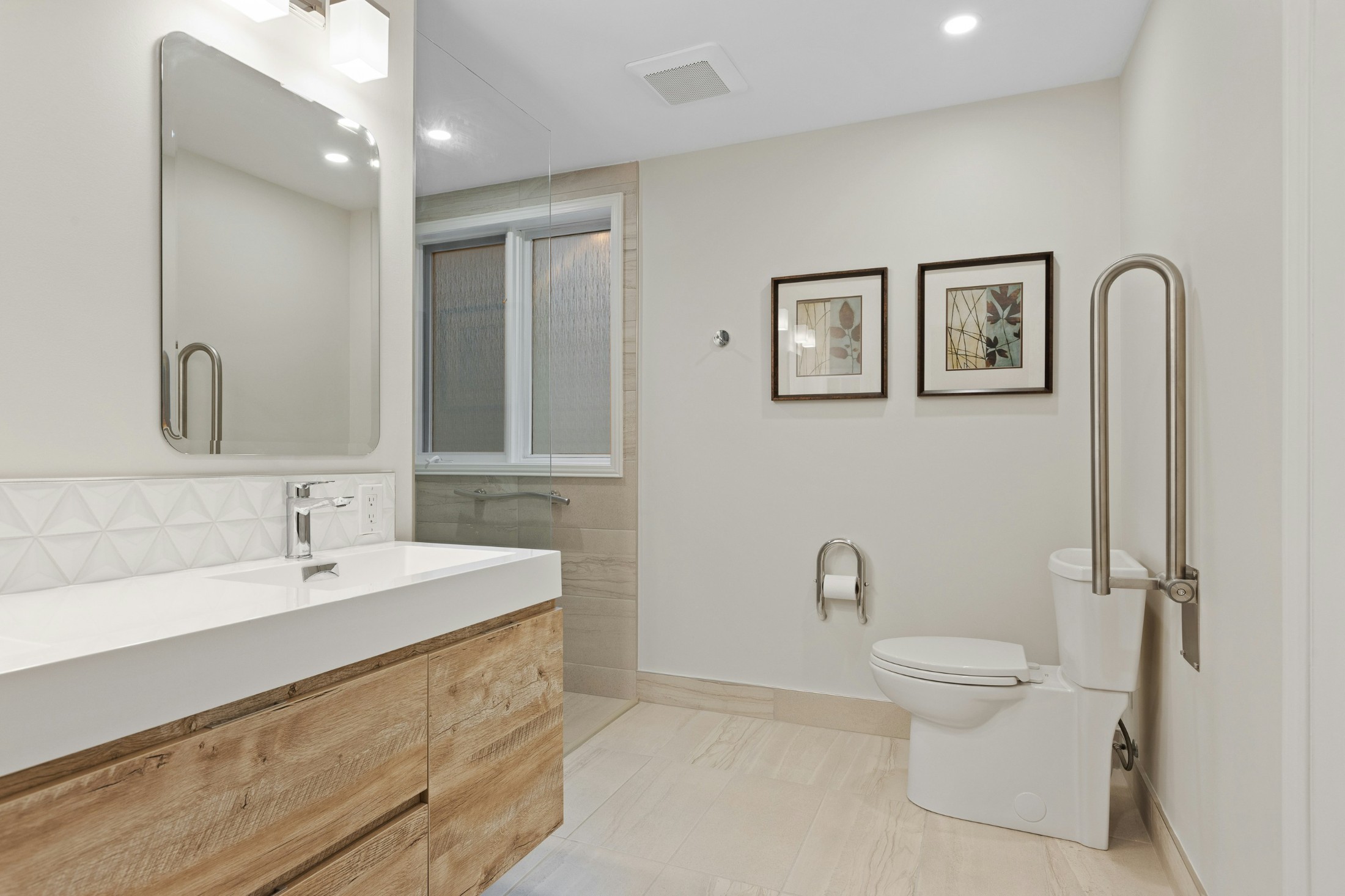 Accessible bathroom with a grab bar beside the toilet, wall-mounted vanity and open floor space